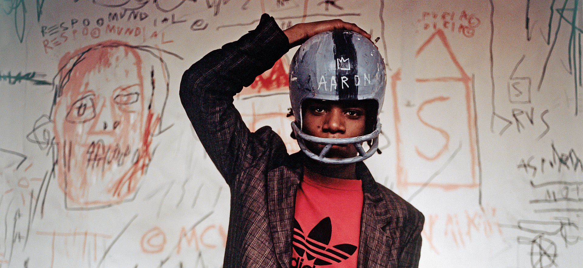 Edo Bertoglio, Jean-Michel Basquiat wearing an American football helmet, 1981, Photo: © Edo Bertoglio, courtesy of Maripol, Artwork: © VG Bild-Kunst Bonn, 2018 & The Estate of Jean-Michel Basquiat, Licensed by Artestar, New York