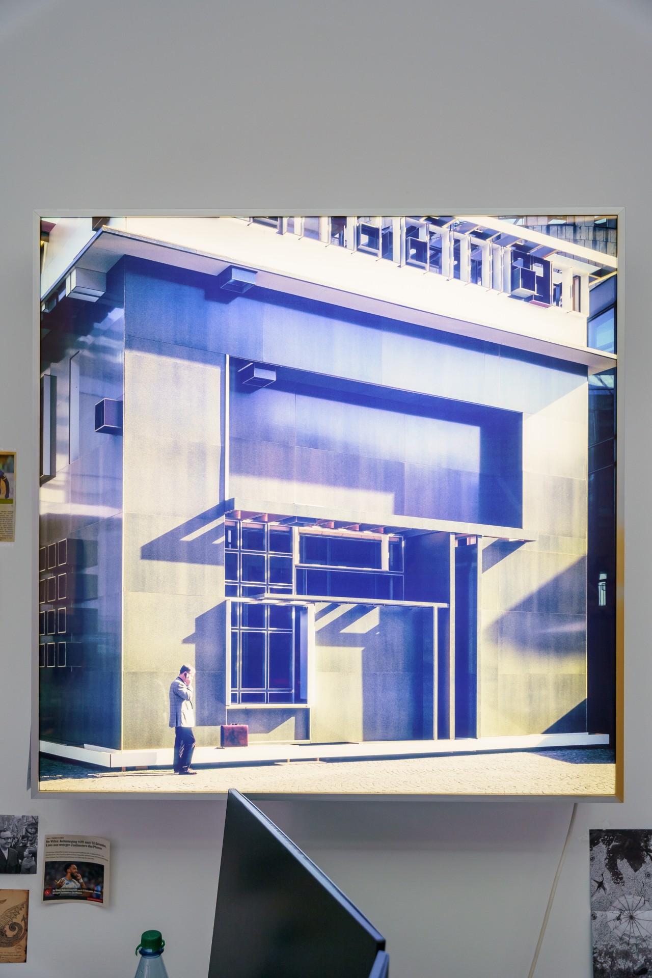 Moderne Architektur mit geometrischen Formen, einem Mann mit Koffer und Schatten auf der Fassade.