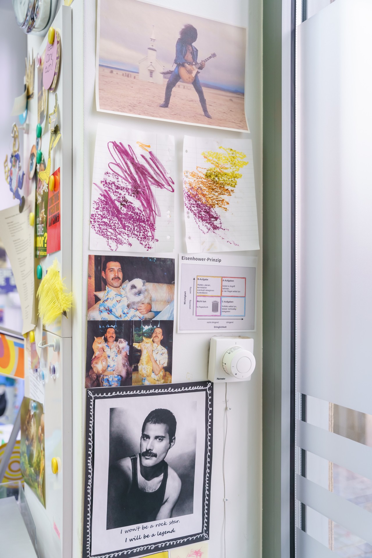 Collage aus Fotos, Zeichnungen und einem Zitat von Freddie Mercury an einer Wand. Bunte, persönliche Atmosphäre.