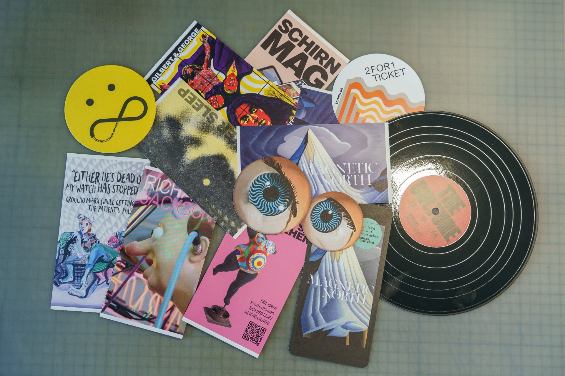 Kreative Collage aus Postkarten, Magazinen, einem Schallplattencover und einem gelben Smiley.