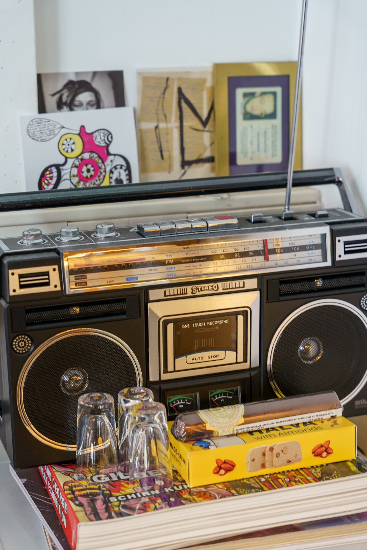 Ein Vintage-Radiogerät mit Brille, Snacks und bunten Büchern im Hintergrund.