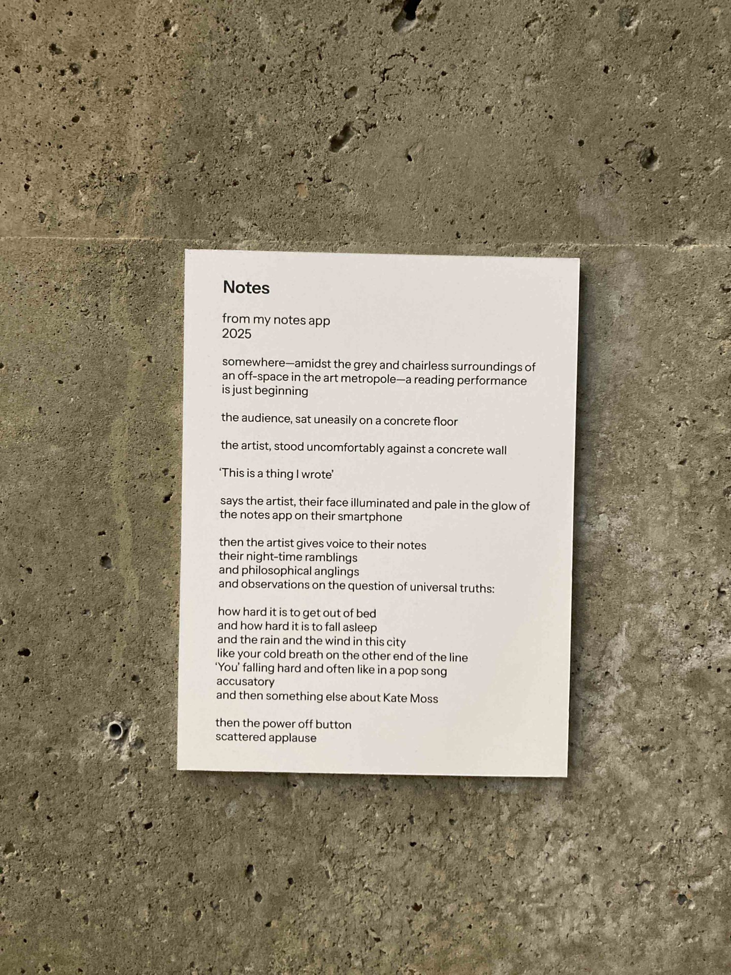 Notizen auf einem Blatt Papier an einer grauen Wand fangen einen künstlerischen Lesemoment ein.