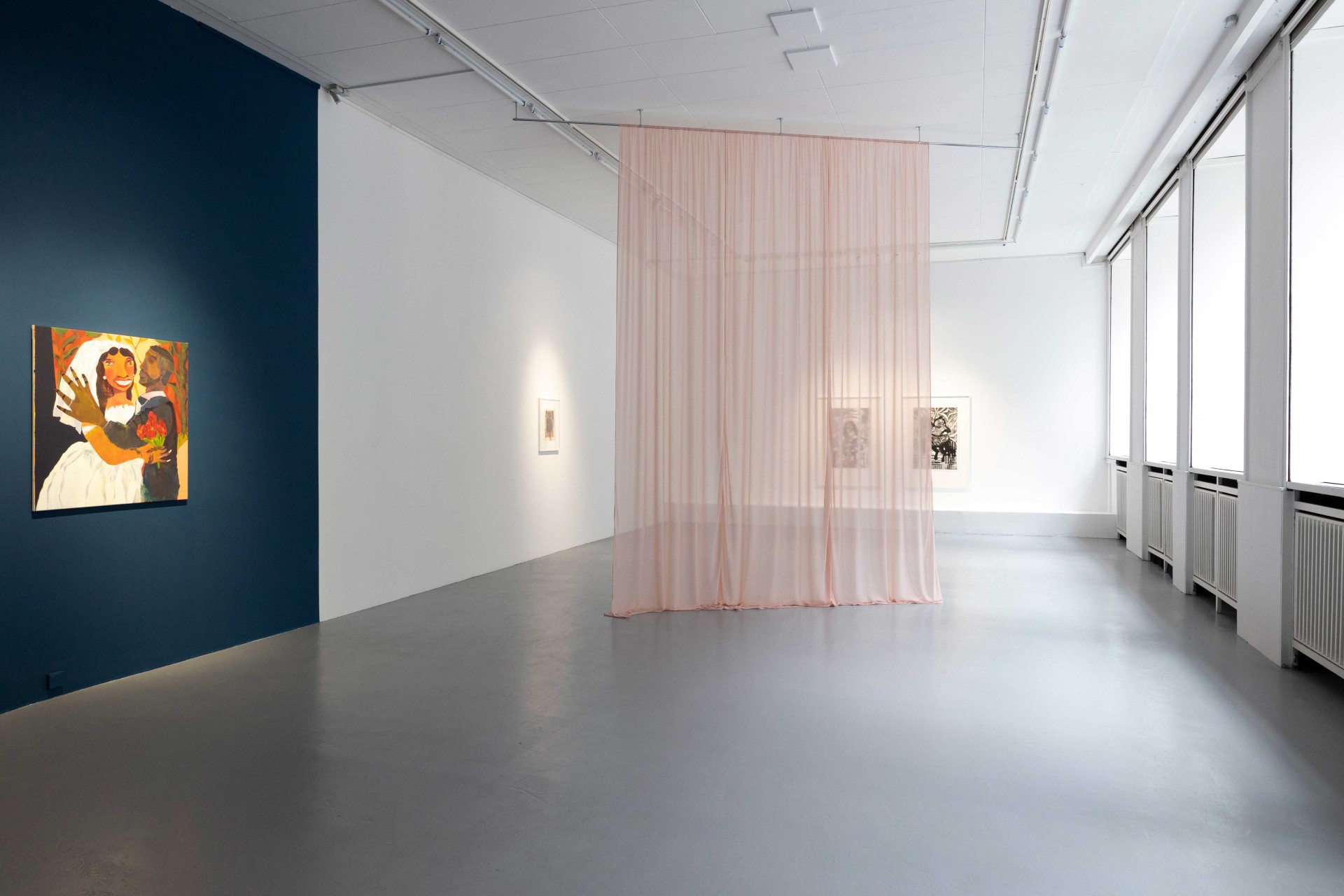 Modern art gallery with colorful paintings and a translucent curtain in a bright room.