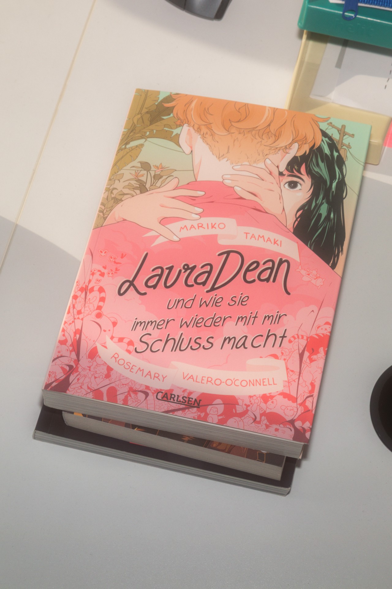 Buchcover von "Laura Dean und wie sie immer wieder mit mir Schluss macht" mit Illustrationen und pinkem Hintergrund.