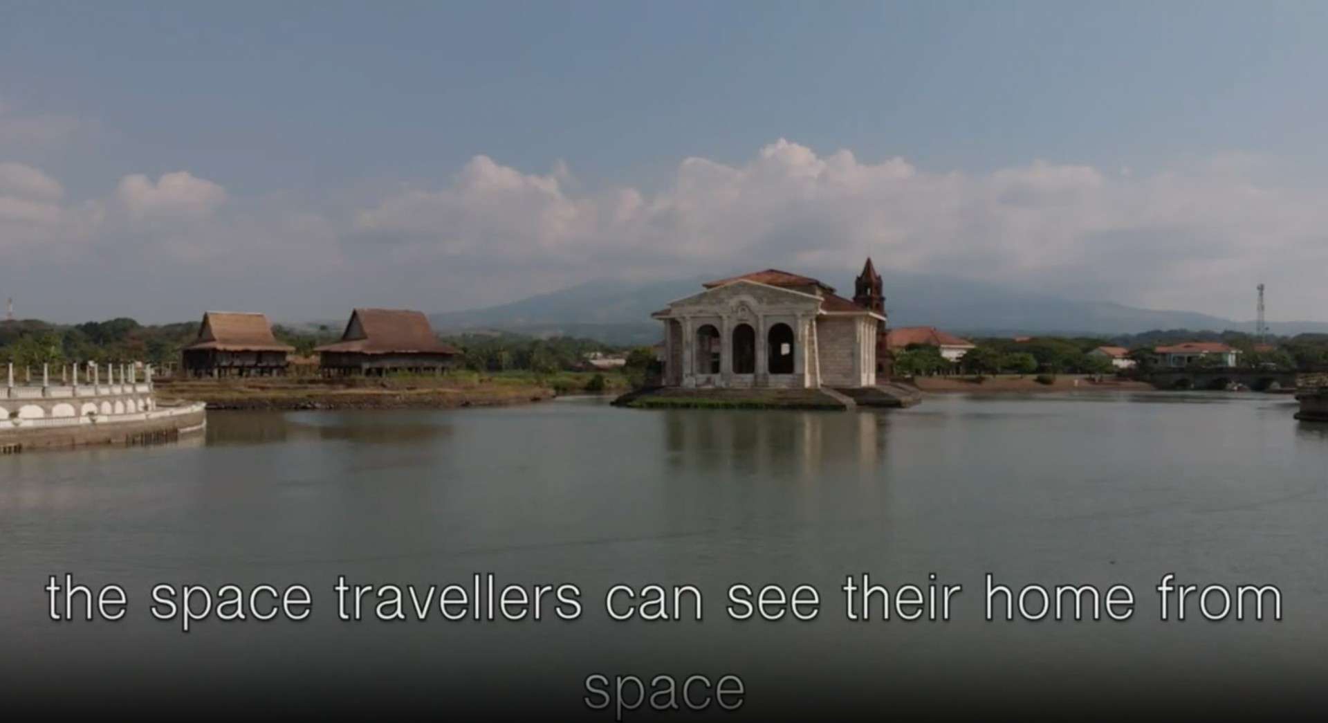 Landschaft mit Wasser, historischen Gebäuden und Bergen, unterbrochen von einem Text über Astronauten.