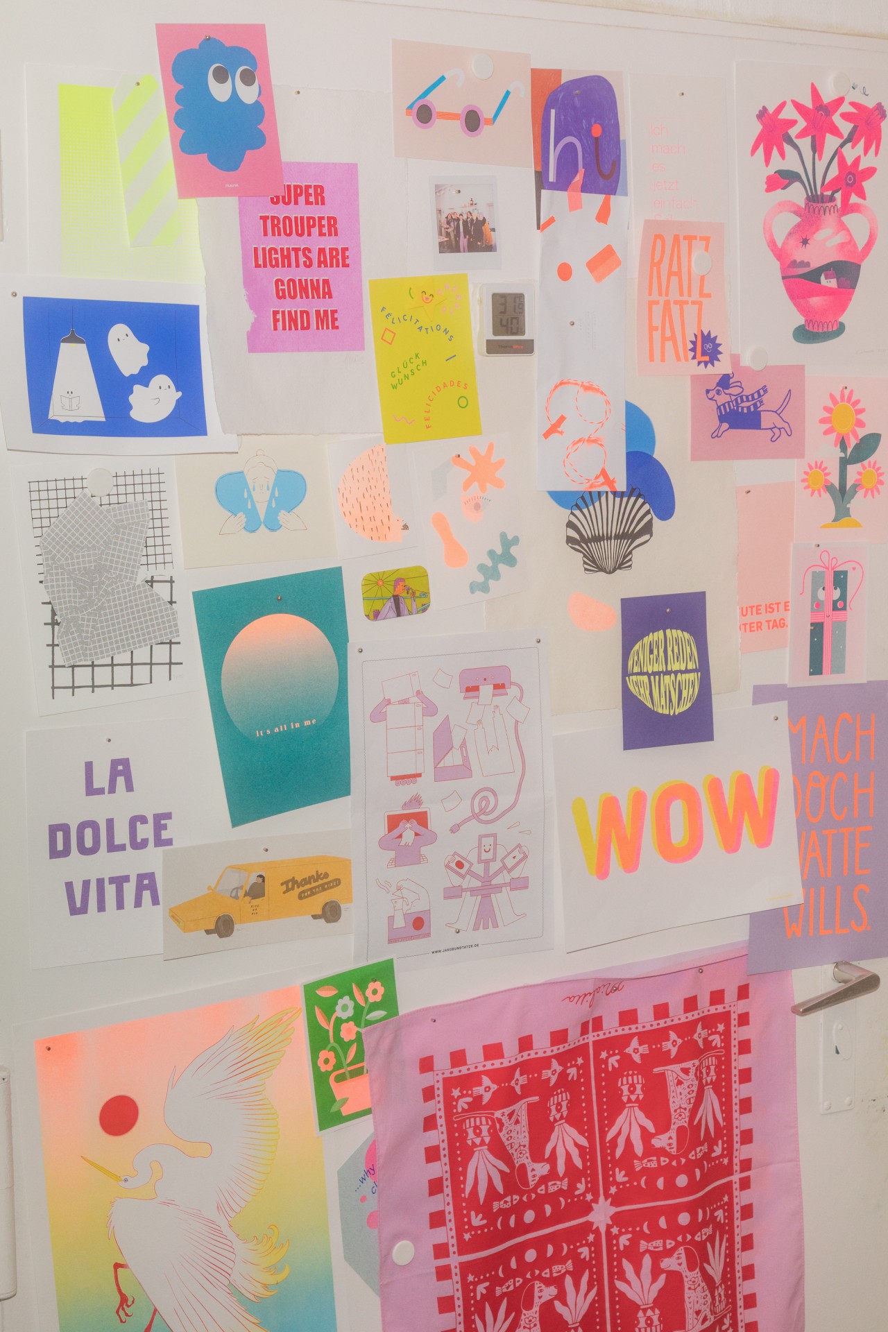 Bunte Collage aus Plakaten und Drucken an einer Wand. Energetische Farben und kreative Designs.