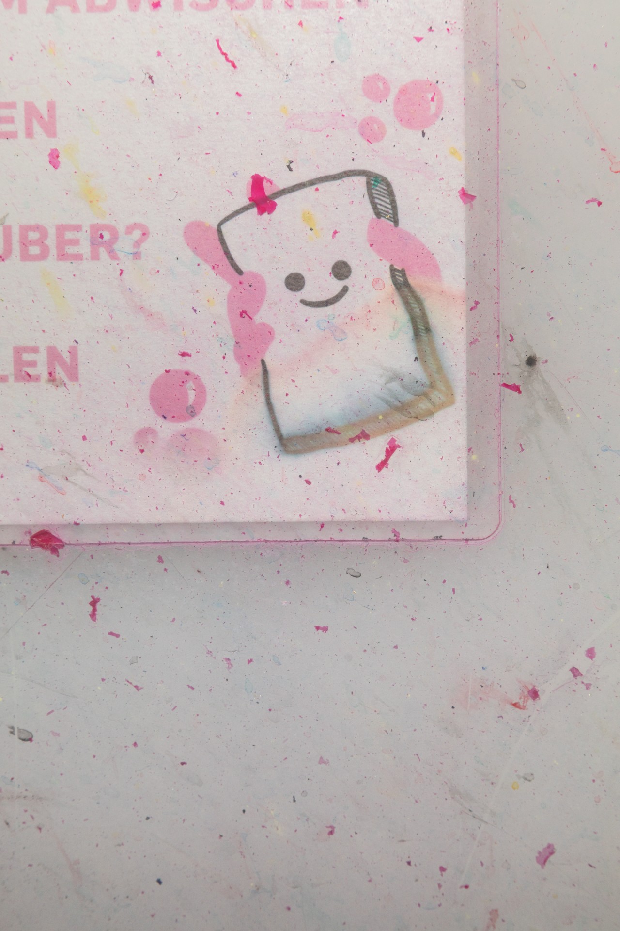 Fröhlicher, gezeichneter Toast mit Gesicht und Zahnbürste, umgeben von bunten Farbspritzern auf hellem Hintergrund.