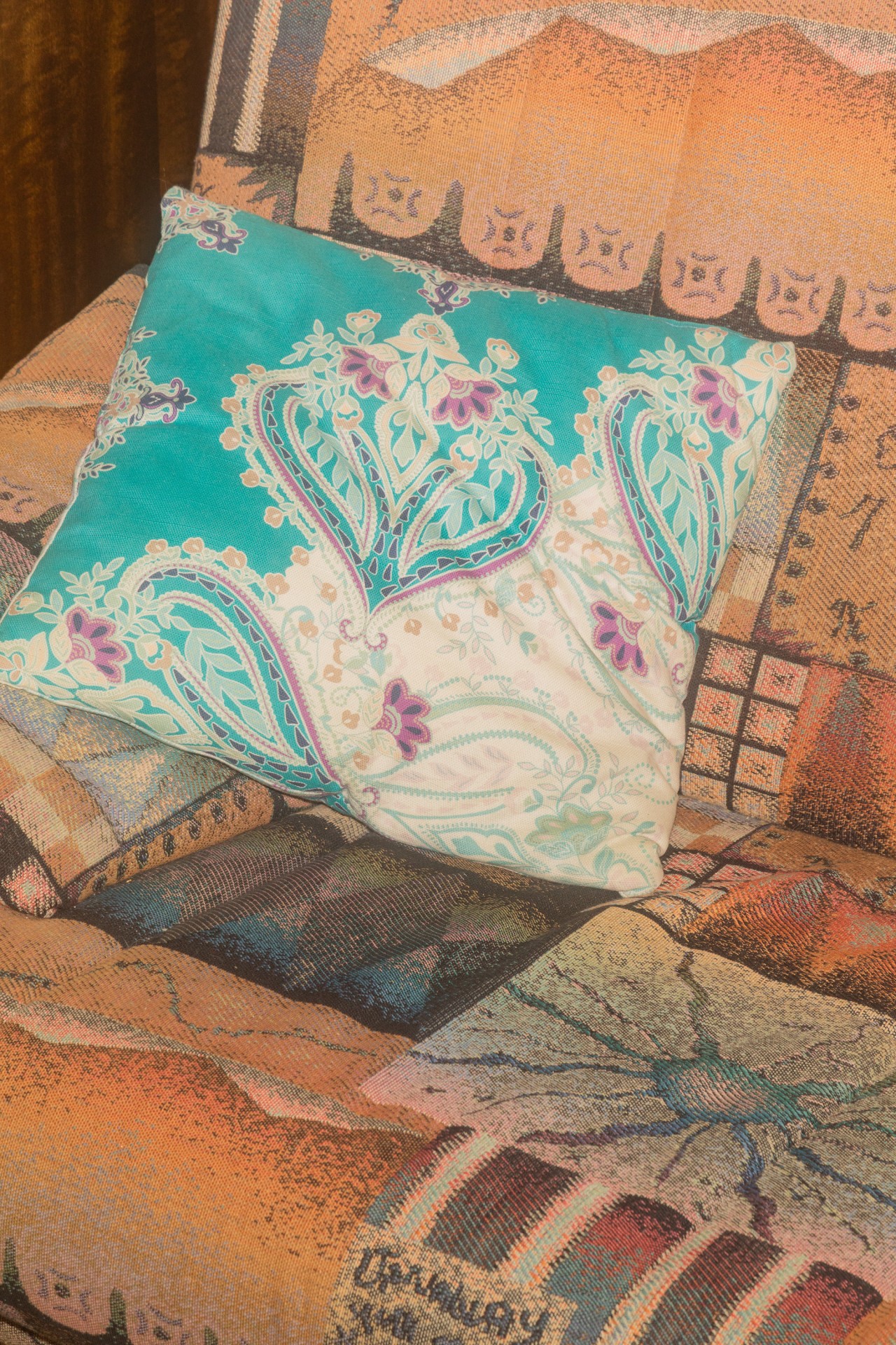 Bunt gemustertes Kissen auf einem farbenfrohen Sofa mit einzigartigem Design und Textur.