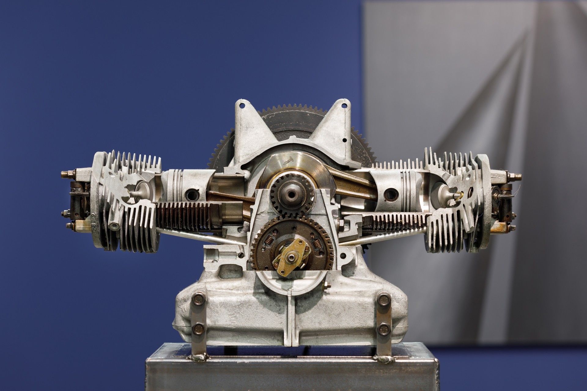 Ansicht eines detaillierten Motorinnenteils mit sichtbaren Zylindern und Mechanismen vor neutralem Hintergrund.
