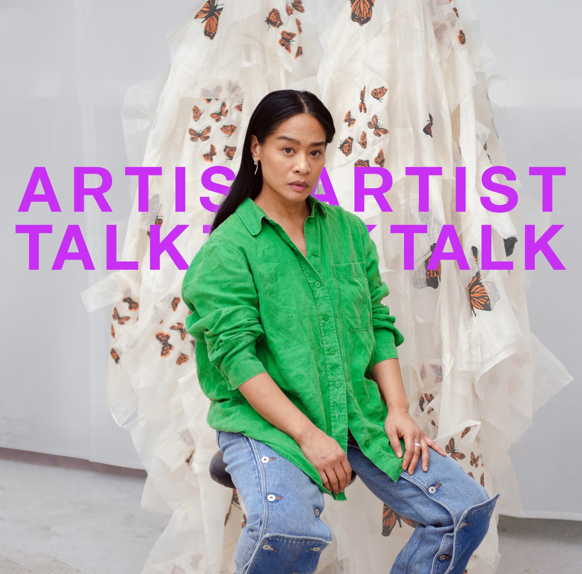 Frau mit langem, dunklem Haar in grüner Bluse sitzt vor einem Schmetterlingsmuster. Titel: "KÜNSTLERGESPRÄCH".