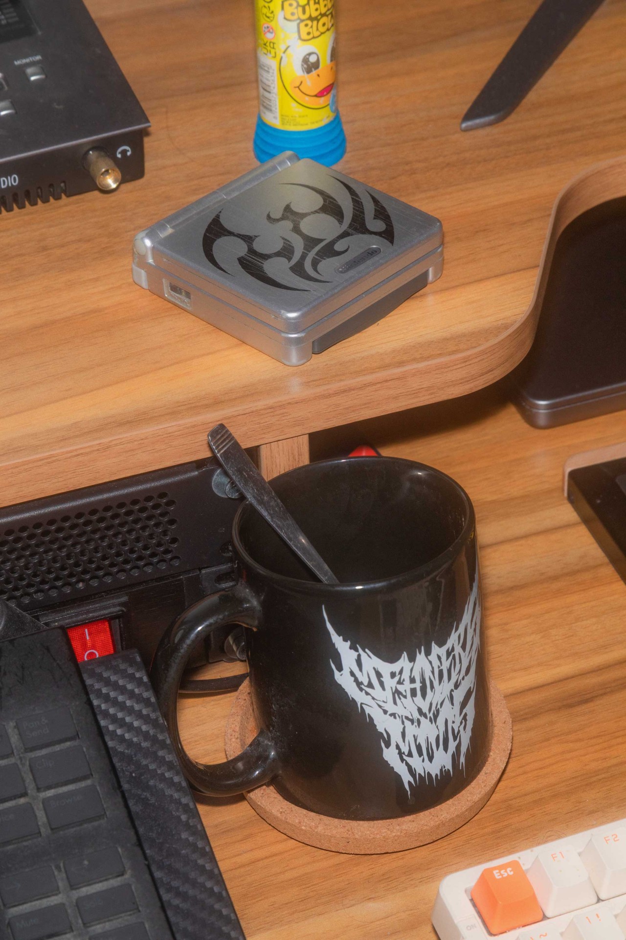 Szene eines Schreibtischs mit einer schwarzen Tasse, einem silbernen Behälter und einem Blasenspielzeug.