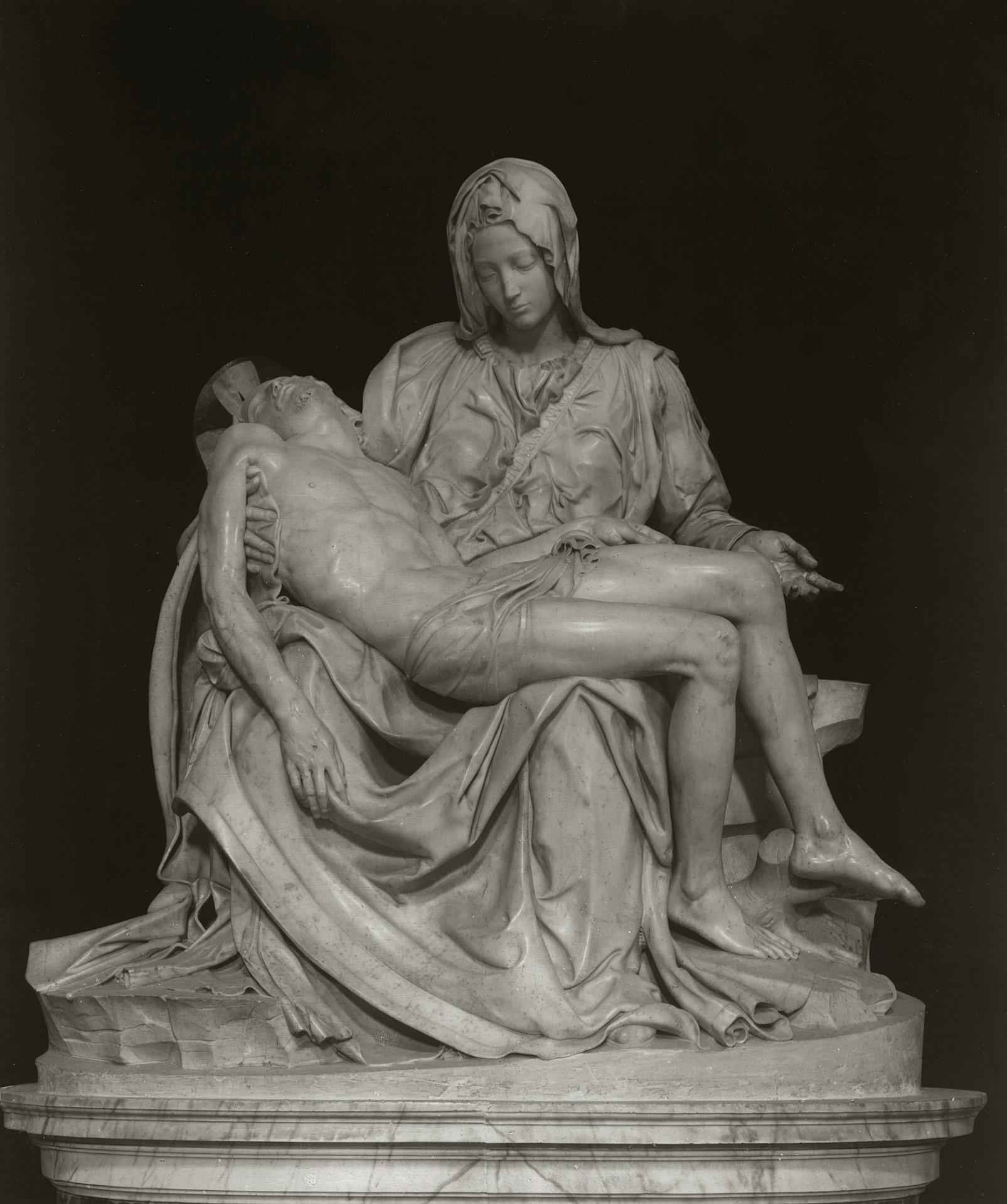 Die Skulptur zeigt Maria in sitzender Position mit ihrem Sohn Jesus, der leblos auf ihren Knien liegt und von ihr gehalten wird. Maria hat den Kopf leicht geneigt und trägt ein langes Kleid mit komplexem Faltenwurf. Jesus ist mit einem einfachen Lendentuch bedeckt. Die beiden Figuren bilden gemeinsam eine Pyramidenform. Die Skulptur ist aus edlem, weißem Marmor gefertigt und hochglänzend poliert. Die Körper sind anatomisch präzise dargestellt. Maria ist jedoch deutlich größer als ihr Sohn dargestellt.