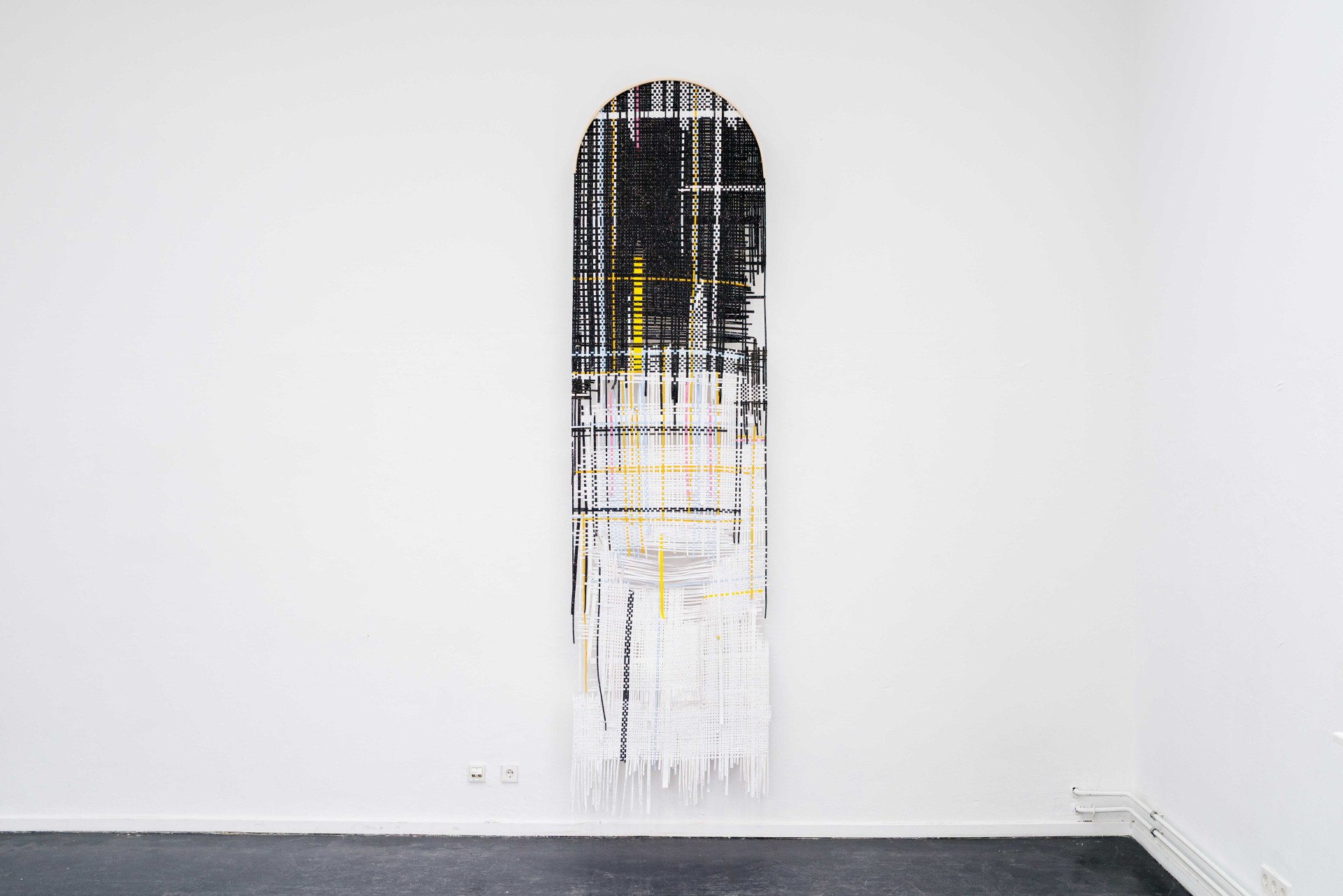 Abstrakte Wandkunst in Schwarz, Weiß und Gelb mit geschwungenem oberen Rand und hängenden Elementen.