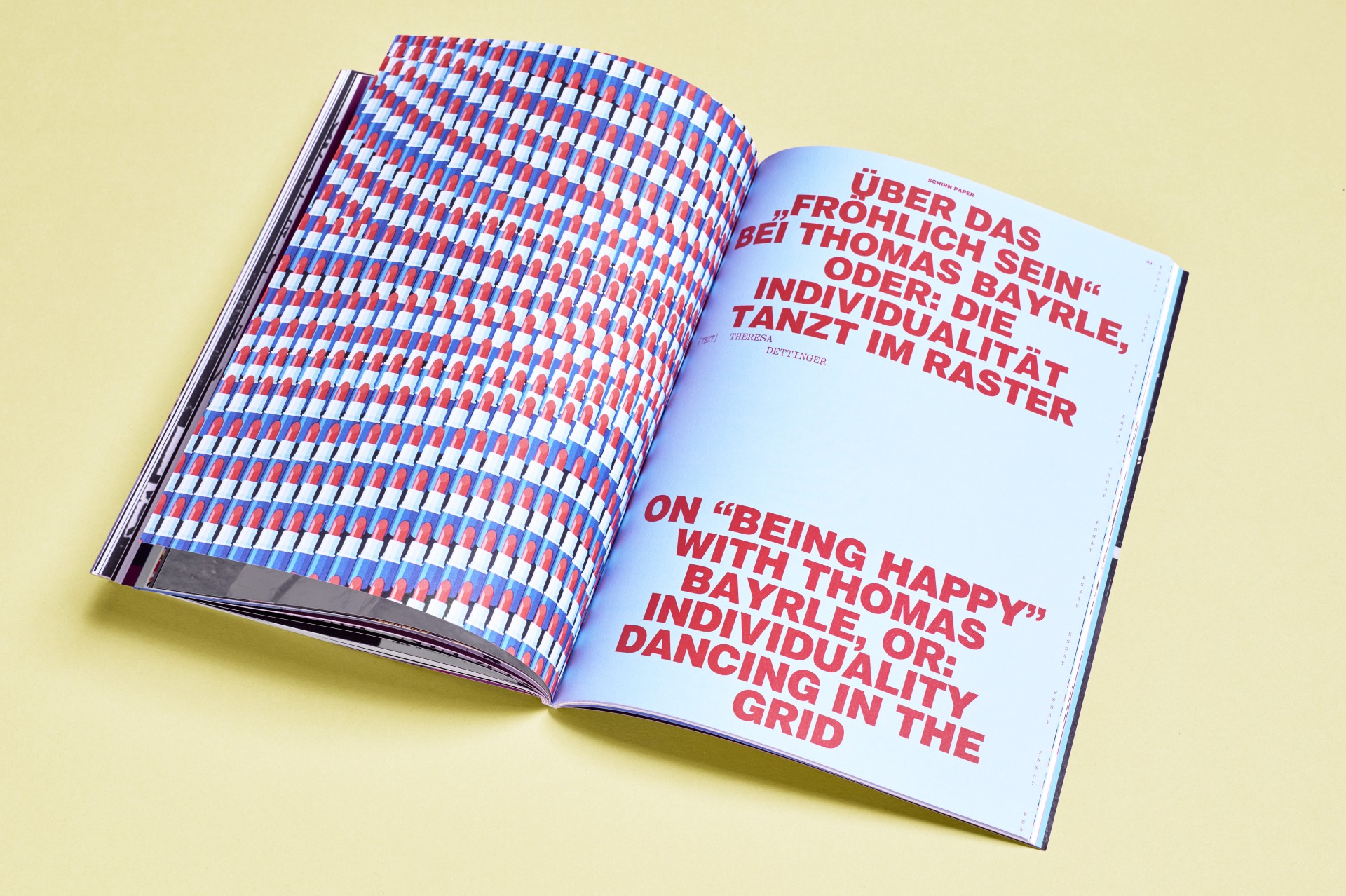 Offenes Magazin mit buntem Muster und großen weißen Schriftzügen auf blauem Hintergrund.