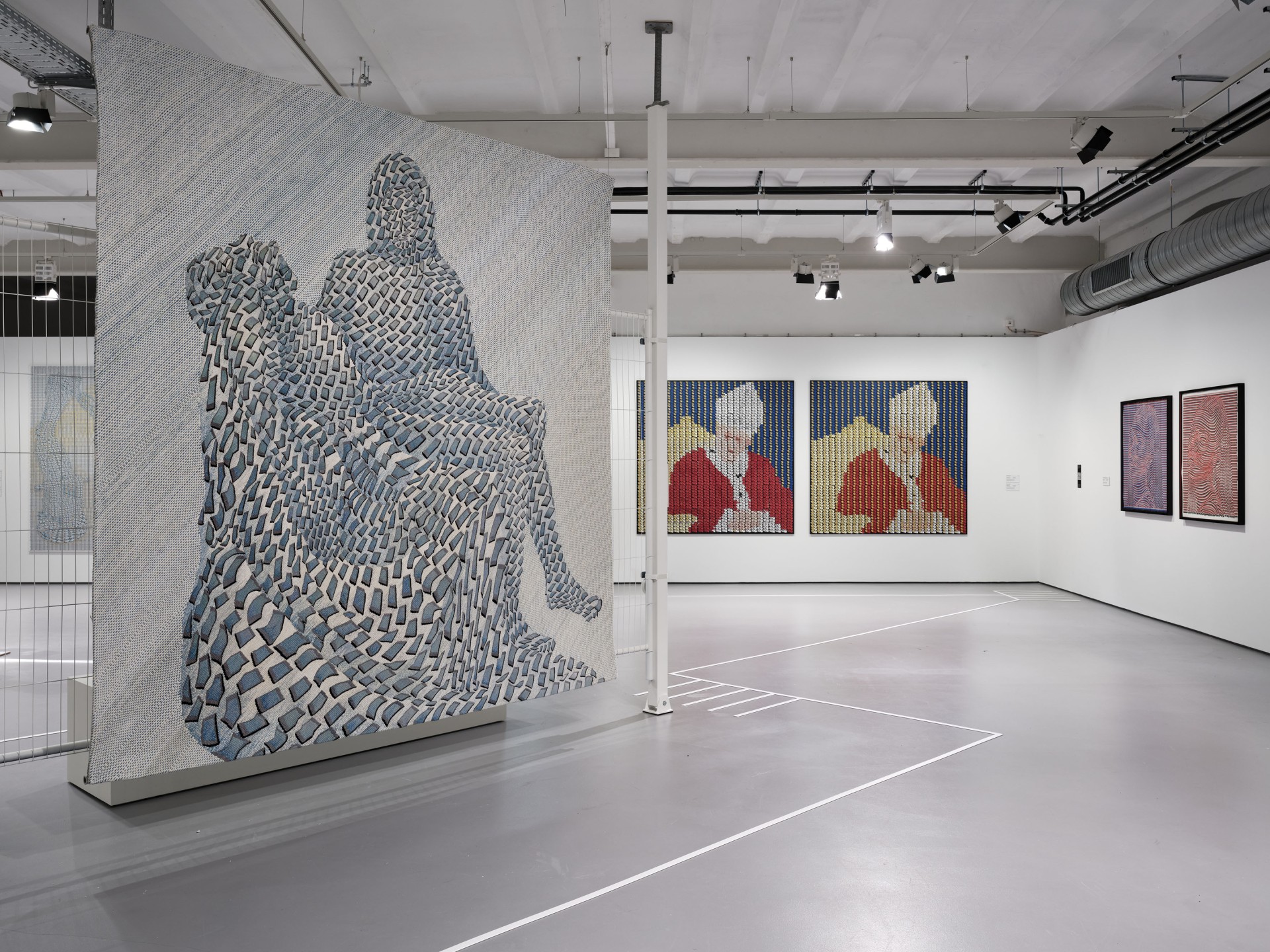 Moderne Kunstgalerie mit Wandteppichen und Bildern in kreativen Mustern und lebhaften Farben.