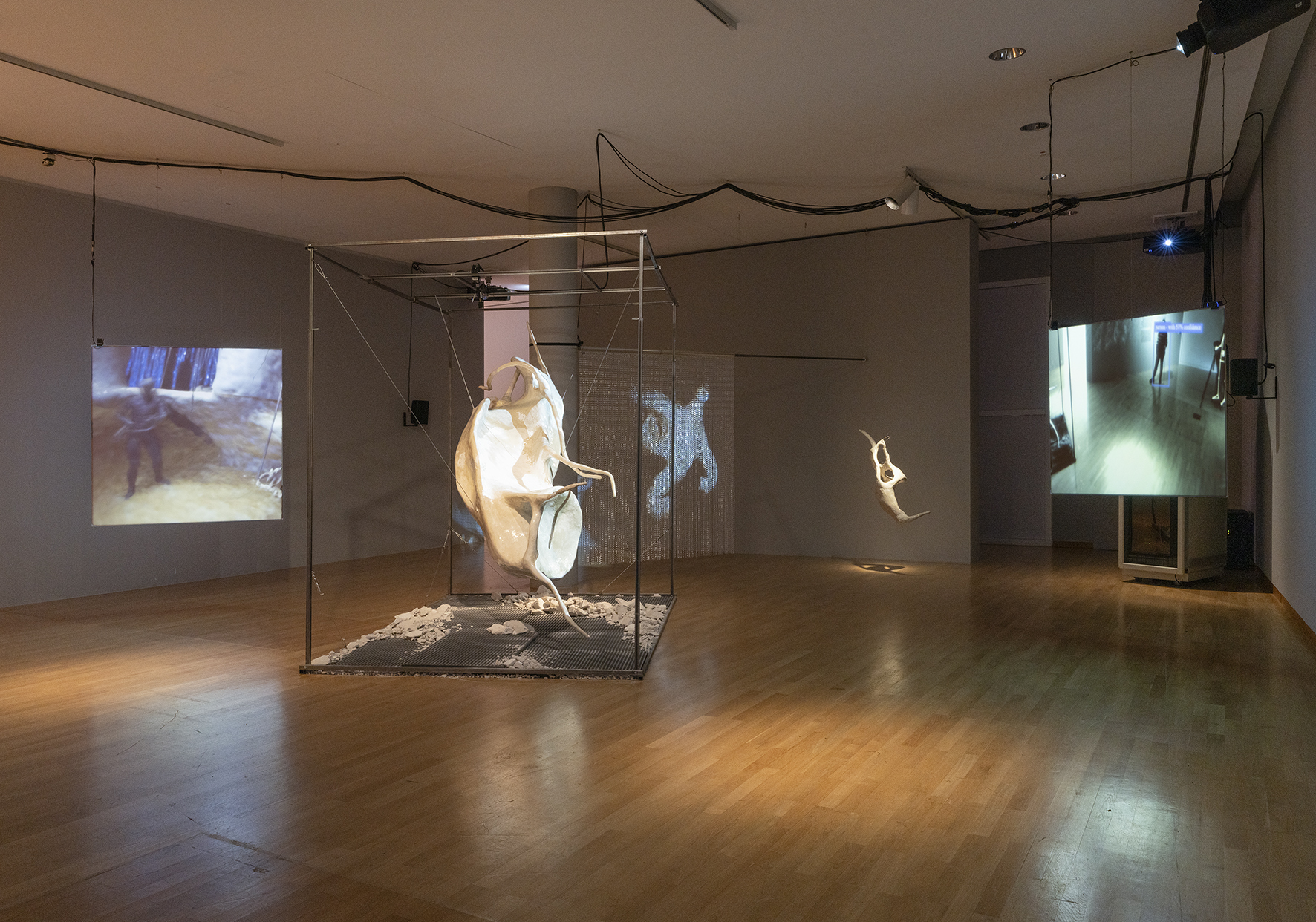 Moderne Kunstinstallation mit Projektionen, skulpturalen Elementen und minimalistischem Raumdesign.