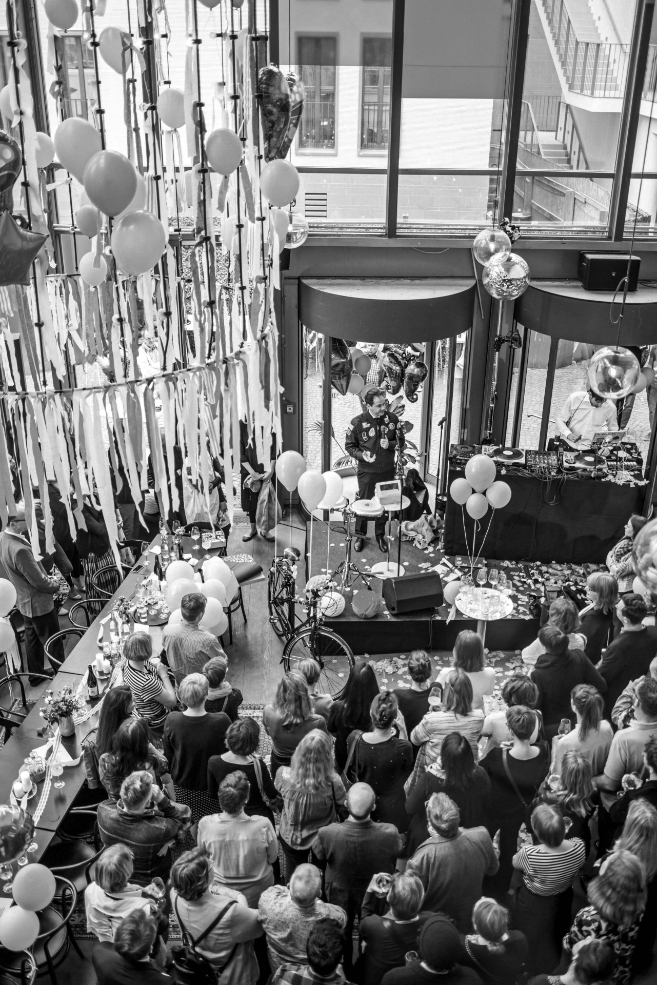 Feierliche Veranstaltung mit Pferden im Publikum, Luftballons und einem Redner auf einer Bühne in modernem Raum.