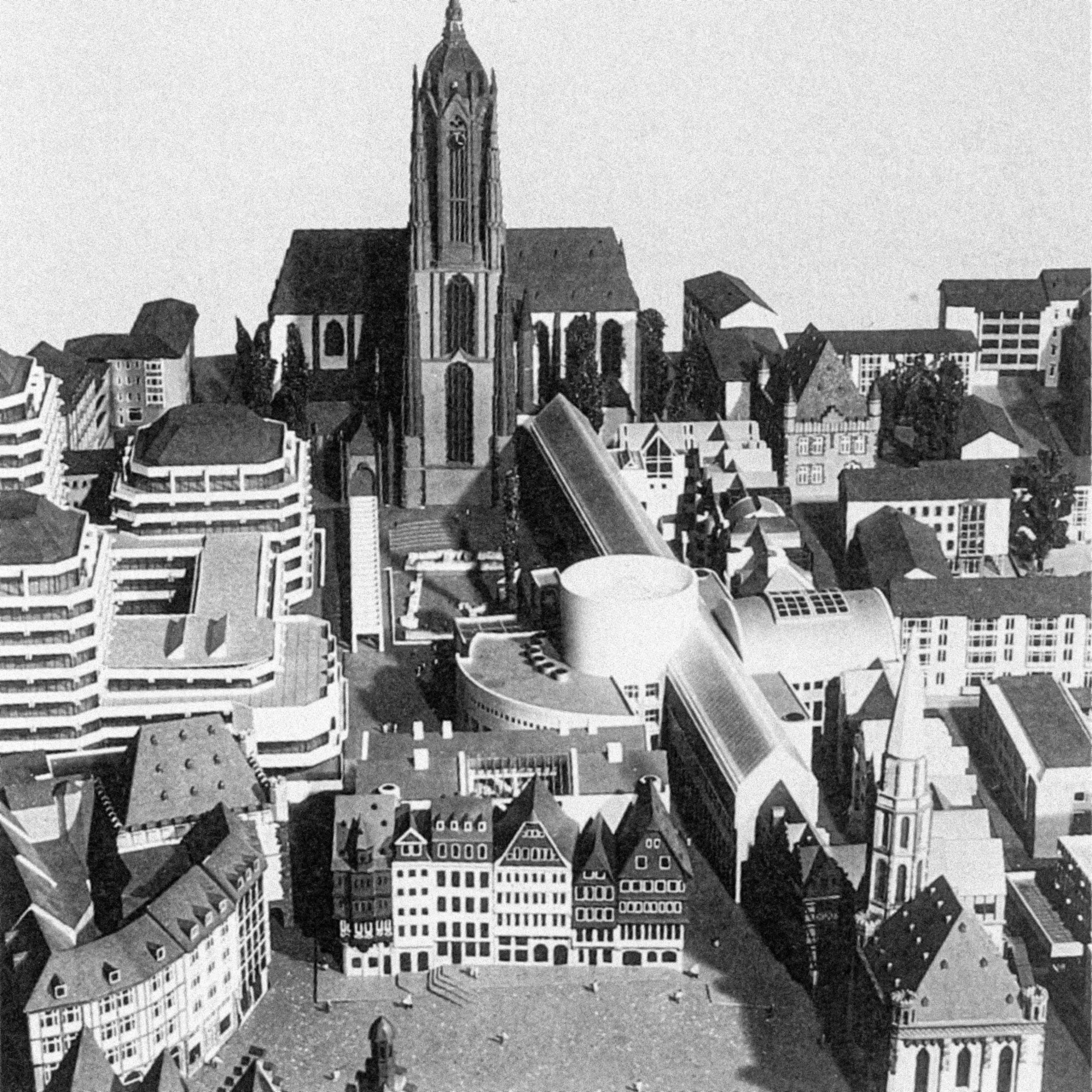Modell einer Stadt mit historischer Architektur und modernen Gebäuden, im Hintergrund ein zentraler Kirchturm.