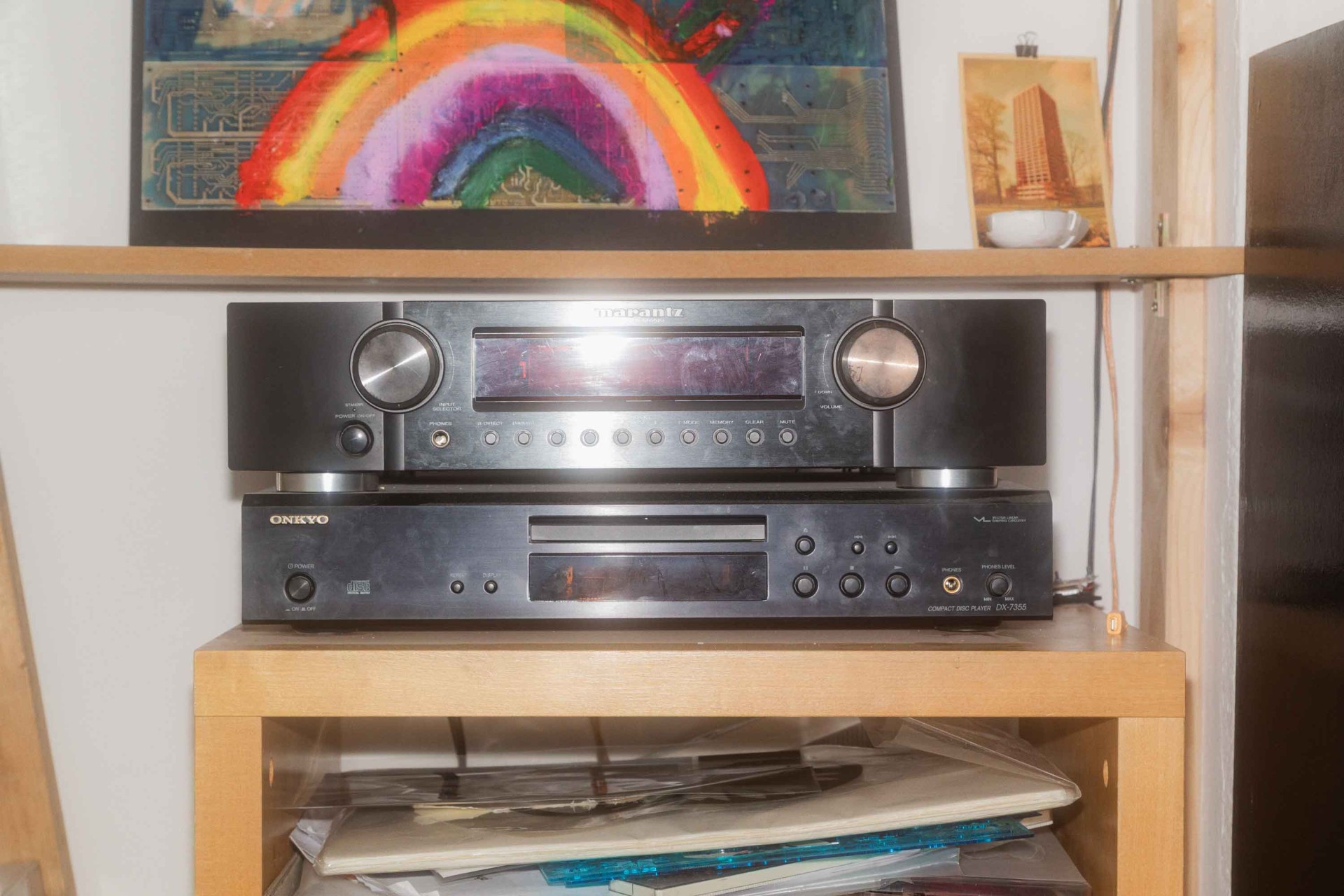 Zwei Heim-Audio-Geräte: oben ein Marantz Receiver, darunter ein Onkyo CD-Player auf einem Holzregal.