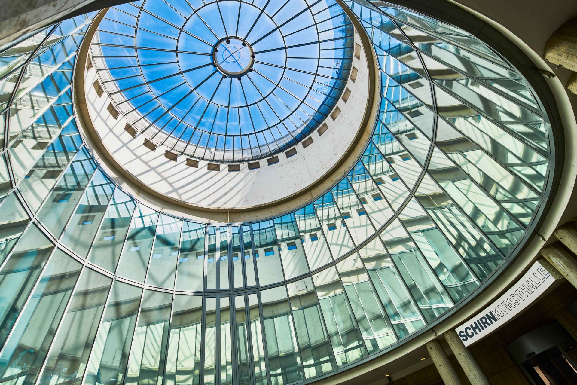 Glasdach einer modernen Halle mit zentralem Lichterspiel und beeindruckender Architektur.