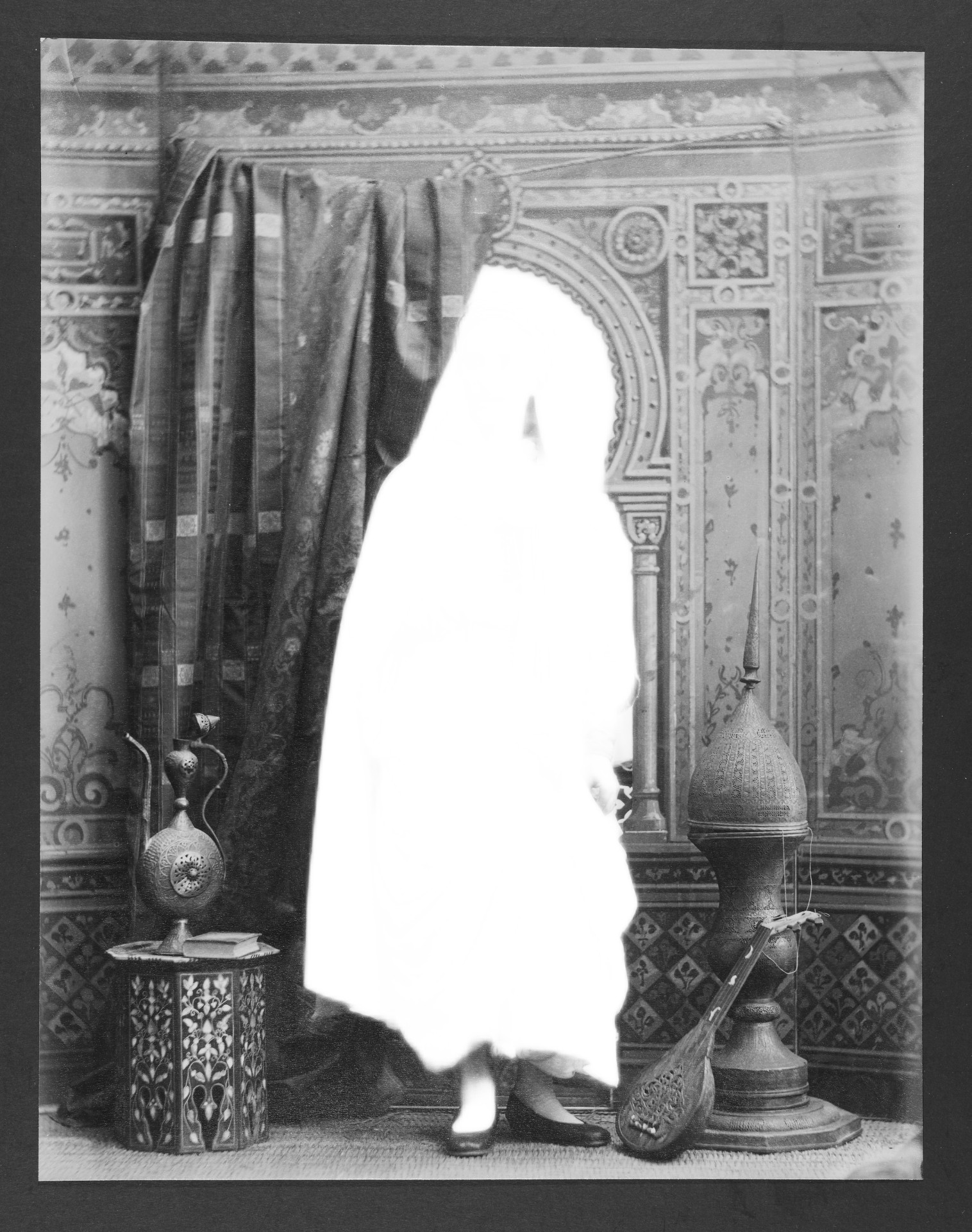 Ein unscharfes, historisches Porträt einer Person in traditioneller Kleidung vor einem orientalischen Hintergrund.