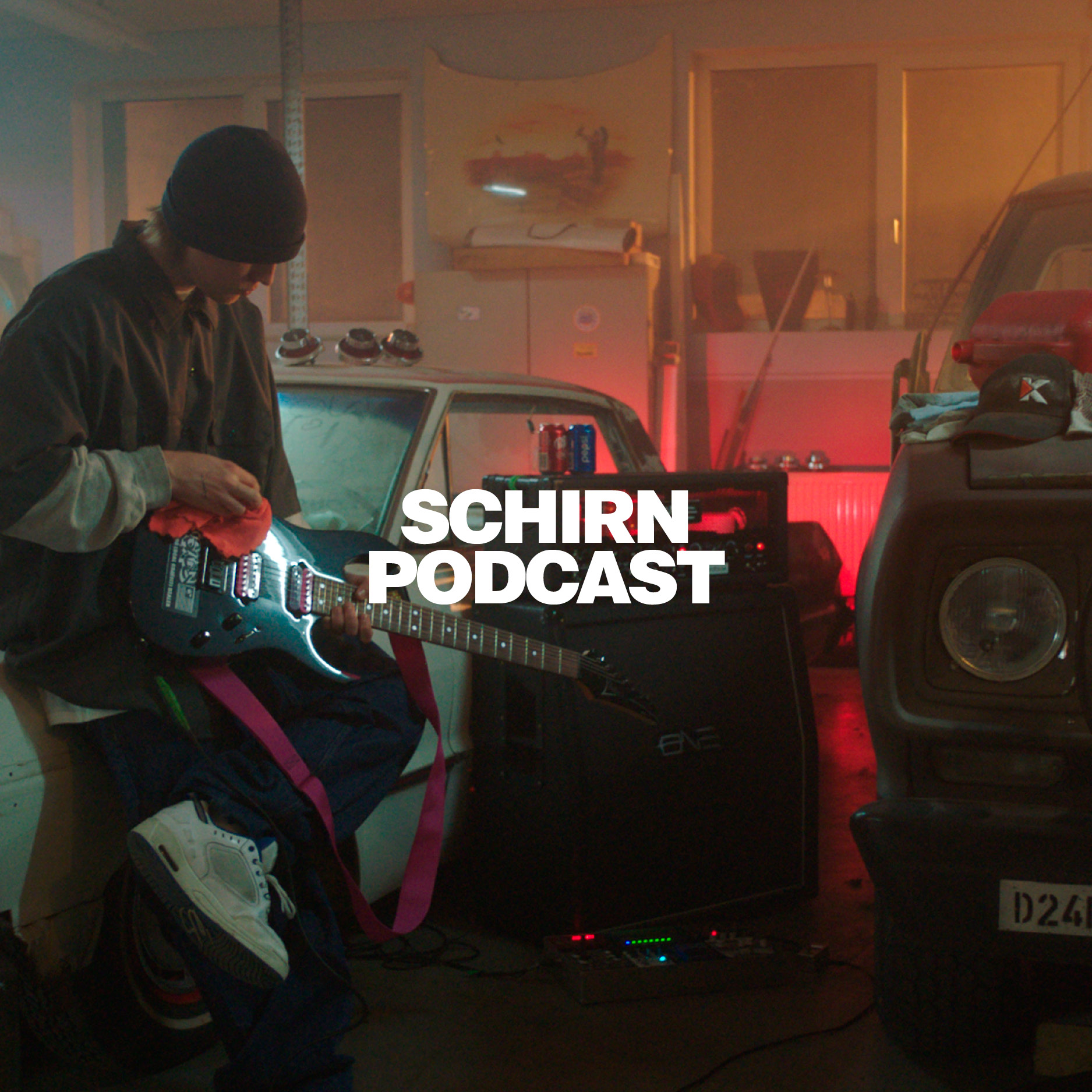 Junger Musiker in einer Garage mit Gitarre, umgeben von Autos und Podcast-Elementen, im gedämpften Licht.