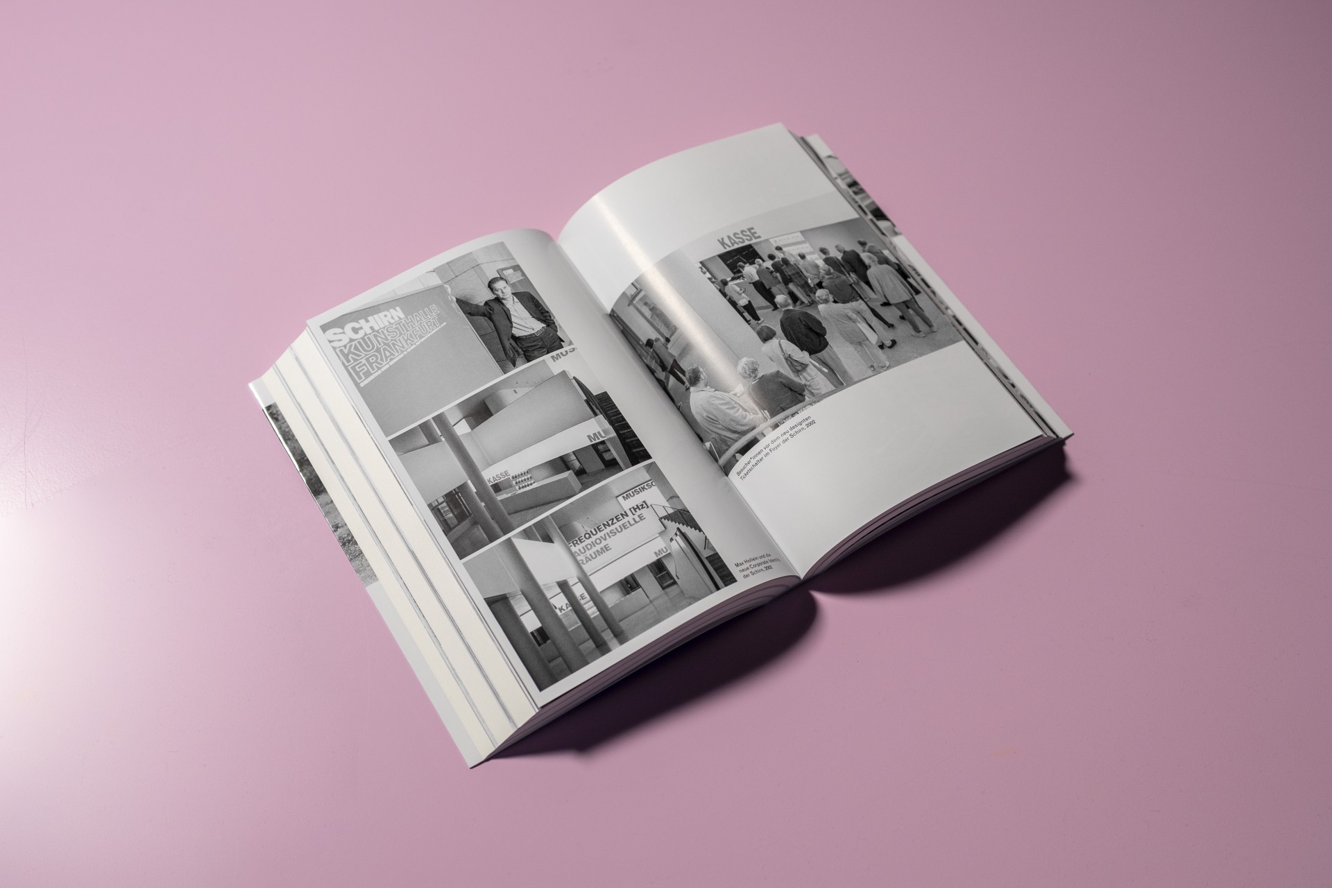 Geöffnetes Buch auf pinkem Tisch mit Schwarz-Weiß-Fotos und Texten zur Schirn Kunsthalle Frankfurt.