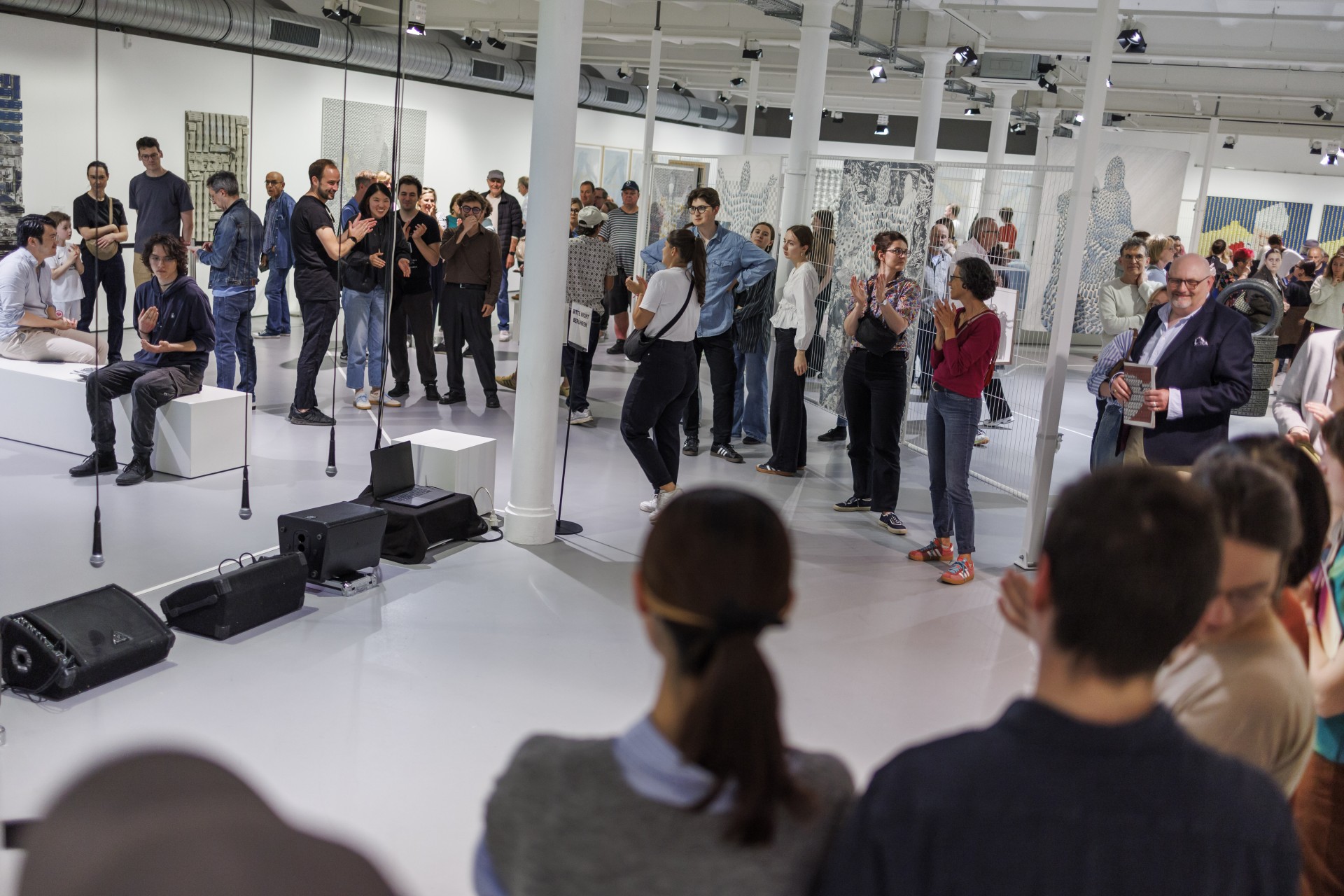 Verschiedene Personen in einer Kunstgalerie, die eine Veranstaltung oder Ausstellung besuchen.