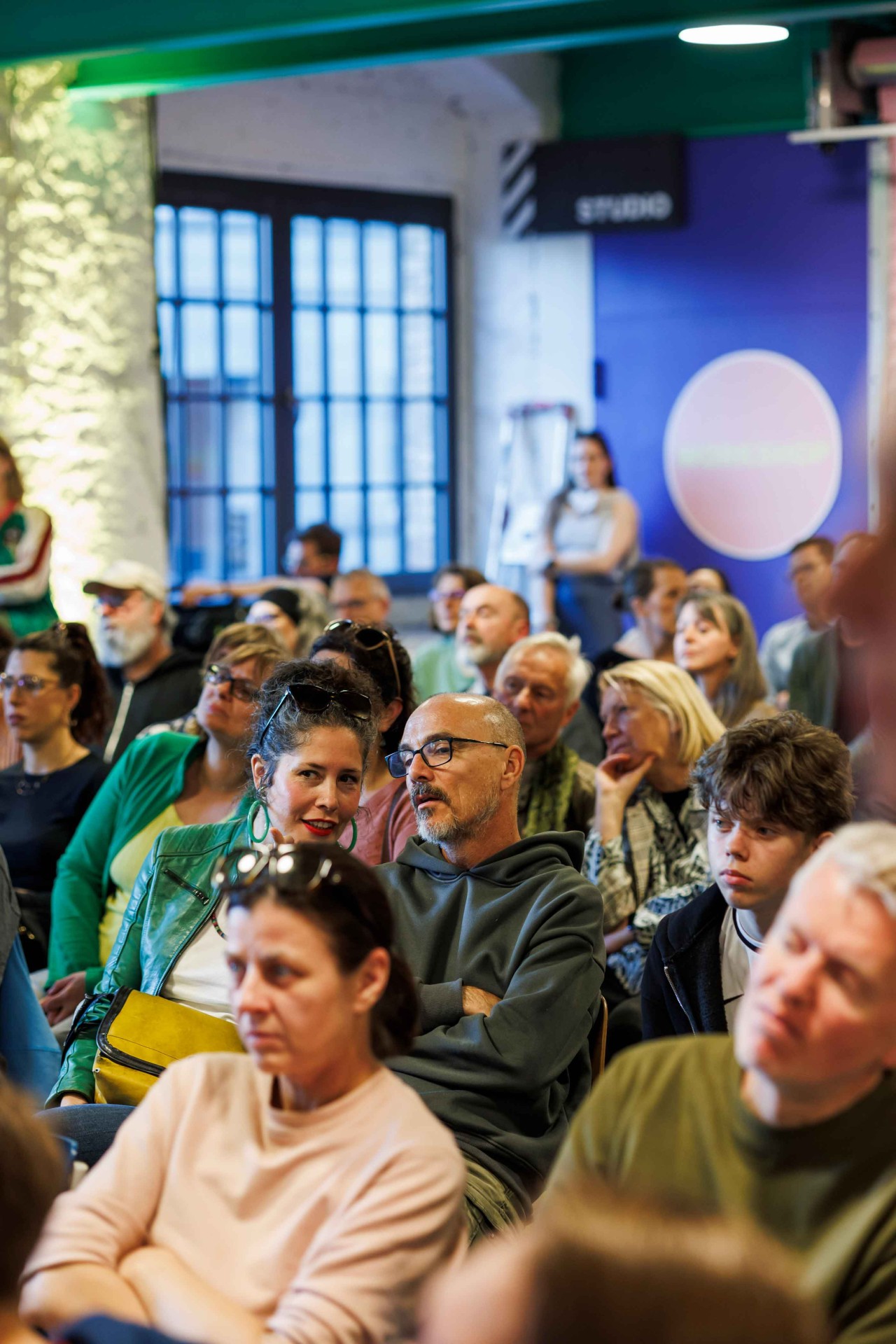 People in a room, attentive and engaged in conversations while attending an event.